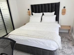 een slaapkamer met een groot bed met een zwart hoofdeinde bij Zuri Marula Luxe in Midrand +15 foto's