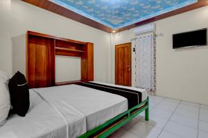 a bedroom with a bed and a blue ceiling at OYO 95019 Jeppi Homestay in Kedungsari +21 photos