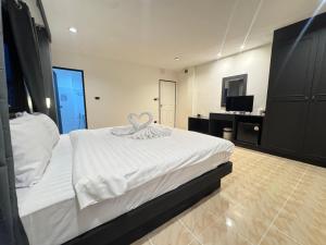 a bedroom with a large white bed and a television at Chapter 26 in Patong Beach