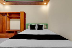 a bedroom with a large bed with black and white sheets at OYO 95019 Jeppi Homestay in Kedungsari