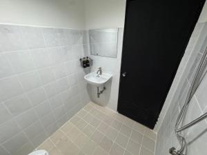 a white bathroom with a sink and a mirror at Chapter 26 in Patong Beach