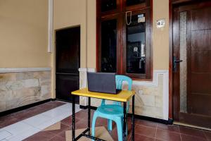 a desk with a laptop computer on top of it at OYO 95035 Harmony Guest House Syariah Sawojajar in Ngadipuro +27 photos