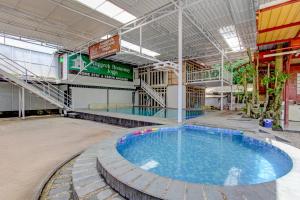uma grande piscina em um grande edifício em OYO 95018 Anggrek Homestay Jogja Syariah em Timuran
