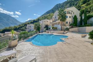 a house with a swimming pool with mountains in the background at Kotor Vista Seaview 2 apartment by MN Property in Muo