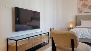 1 dormitorio con TV, silla y cama en Comfortable & Stylish, Steps from F1 Arena!, en Abu Dabi