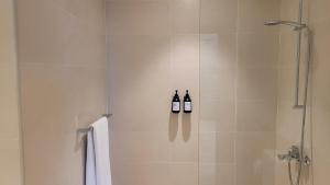 2 botellas de vino en una ducha en el baño en Comfortable & Stylish, Steps from F1 Arena!, en Abu Dabi