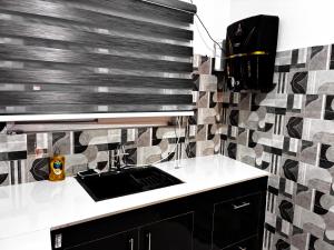 a kitchen with a sink and a tile wall at Baidehi Cottage in Rishīkesh +12 photos