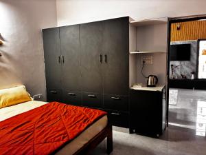 a bedroom with gray cabinets and a red bed at Baidehi Cottage in Rishīkesh