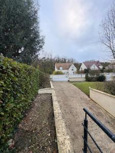 a dirt road in a yard with a fence at Le cocon bleu, duplex cosy et lumineux in Précy-sur-Oise