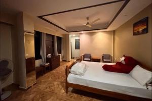 a bedroom with a bed with red pillows on it at Sacred Grove Homestay in Kalimpong