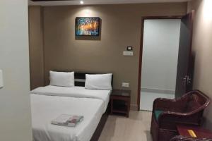 a hotel room with two beds and a chair at Sacred Grove Homestay in Kalimpong +2 photos