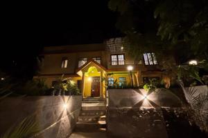 a house with a yellow front door at night at Sacred Grove Homestay in Kalimpong