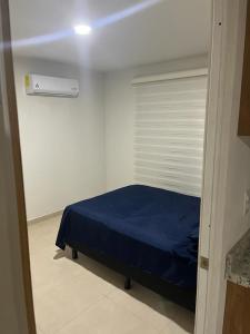 a bedroom with a blue bed and a window at Apartment with pool in Culiacán