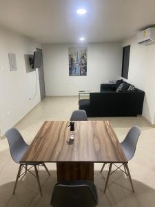 a living room with a wooden table and a couch at Apartment with pool in Culiacán