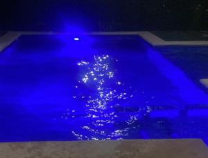a pool with blue lights in the water at night at Apartment with pool in Culiacán +2 photos
