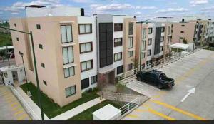 an apartment building with a car parked in a parking lot at Apartment with pool in Culiacán