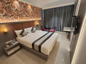 a hotel room with a large bed and a window at Hotel Melody Boutique Thane in Thane +52 photos