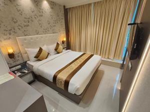 een slaapkamer met een groot bed met een groot raam bij Hotel Melody Boutique Thane in Thane