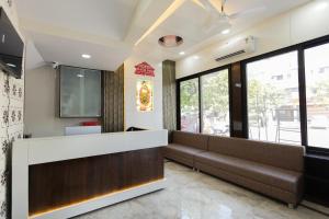 a waiting room with a couch and a tv at Hotel Basil Inn in Ujjain +10 photos