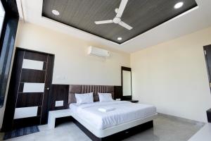 a bedroom with a large bed with a ceiling at Hotel Basil Inn in Ujjain