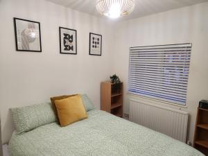 ein Schlafzimmer mit einem Bett und einem Fenster in der Unterkunft Modern 2-Bed Home with great location in Luton in Luton