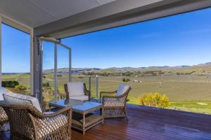a porch with chairs and a table and a large window at Fairhall view in Marlborough Airport
