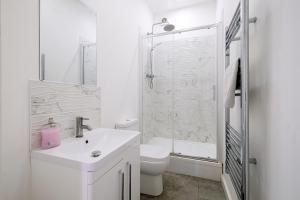Un baño blanco con inodoro y ducha. en 1 Bedroom Apartment, Free Parking, WiFi, en Gloucester