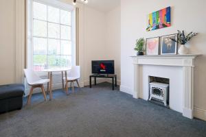 una sala de estar con una mesa y una chimenea en 1 Bedroom Apartment, Free Parking, WiFi, en Gloucester