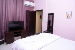 a bedroom with a bed and a tv in it at The Arena Edava in Paravūr
