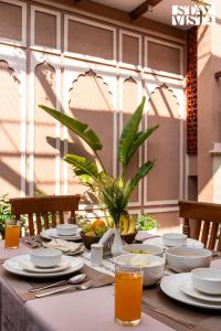 StayVista at Arches and Aura with Terrace, Meals في ماثورا: طاولة عليها صحون وأدوات