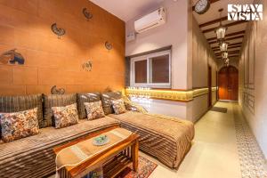 StayVista at Arches and Aura with Terrace, Meals في ماثورا: غرفة معيشة مع أريكة وطاولة