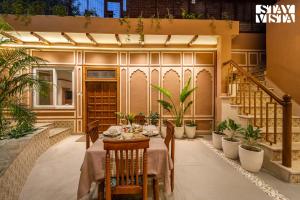 un tavolo da pranzo in un patio con piante di StayVista at Arches and Aura with Terrace, Meals a Mathura
