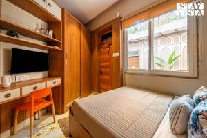 StayVista at Arches and Aura with Terrace, Meals في ماثورا: غرفة نوم بها سرير ومكتب مع تلفزيون