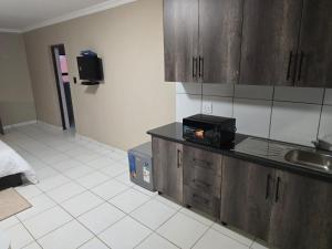 an empty kitchen with a sink and a microwave at La Majestic Guest Lodge in Centurion