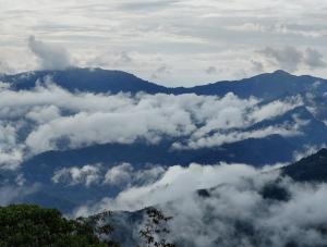a view of clouds and mountains in the sky at Aman magic resort in Takdāh