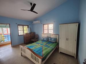 a bedroom with a bed and a ceiling fan at Mati Mogra in Calangute