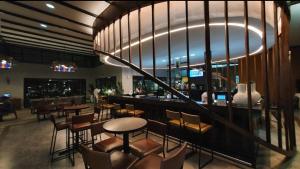 a restaurant with a bar with chairs and tables at Zuri Marula Luxe in Midrand