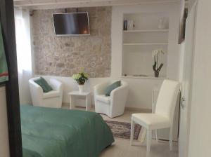 een woonkamer met witte meubels en een tv aan de muur bij Ginetta 2 - Prosecco Hills Holidays in Miane