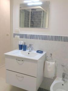 een witte badkamer met een wastafel en een spiegel bij Ginetta 2 - Prosecco Hills Holidays in Miane