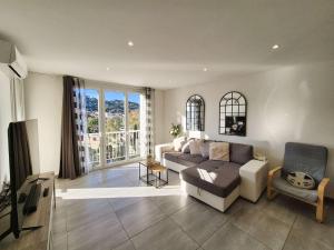 un soggiorno con un divano e una TV di Vue mer, climatisation, plages et commerces à pied a Saint-Mandrier-sur-Mer