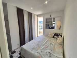 una camera da letto con un letto e una grande finestra di Vue mer, climatisation, plages et commerces à pied a Saint-Mandrier-sur-Mer