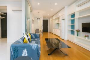 a living room with a blue couch and a glass coffee table at The Platinum Kuala Lumpur by MAHA in Kuala Lumpur
