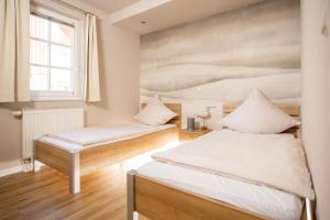 特希尔Hafennest Greetsiel für bis zu 4 Personen - direkt am Hafen - Haustiere herzlich willkommen的有两张床和一扇窗户的卧室