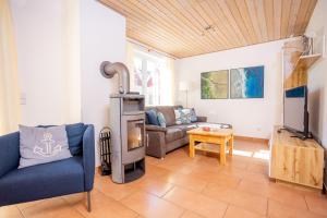 a living room with a couch and a wood stove at Seemannsgarn Greetsiel - tolle Erdgeschosswohnung mit Kaminofen für bis zu 4 Personen - Haustiere herzlich willkommen in Greetsiel