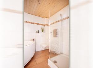 a bathroom with a tub and a toilet and a shower at Seemannsgarn Greetsiel - tolle Erdgeschosswohnung mit Kaminofen für bis zu 4 Personen - Haustiere herzlich willkommen in Greetsiel +17 photos