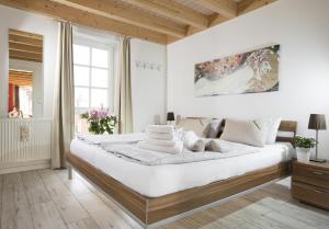 特希尔Schwalbennest Greetsiel für bis zu 6 Personen mit Kaminofen, Whirlpool und Sauna - Haustiere herzlich willkommen, nah am Hafen的一间带一张白色大床的白色大卧室