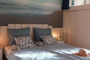 a bedroom with a large bed with two pillows at PiMa aan Zee Julianadorp - charmantes Appartement für bis zu 2 Personen in unmittelbarer Nähe zum Strand - Haustiere herzlich willkommen in Julianadorp