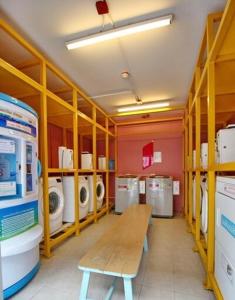 a laundry room with a bench and washing machines at Plum condo Bang-yai station in Nonthaburi