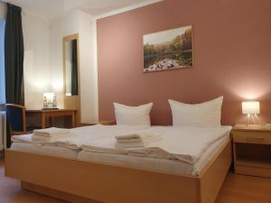 Altenhofbudget seezeit-resort am Werbellinsee的卧室里有一张床，床单和枕头都是白色的