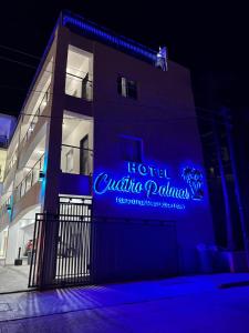 a building with a blue sign on the side of it at Cuatro Palmas Hotel in Puerto Peñasco
